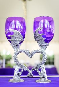 purple glass goblets with metallic dragon stems that link to form a heart.