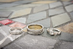described dragon rings and engagement ring on stone tile.